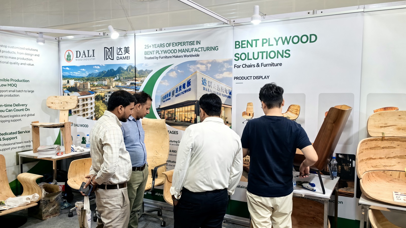 DALI team discussing bent plywood chair components with Indian furniture buyers at INDEXPLUS.