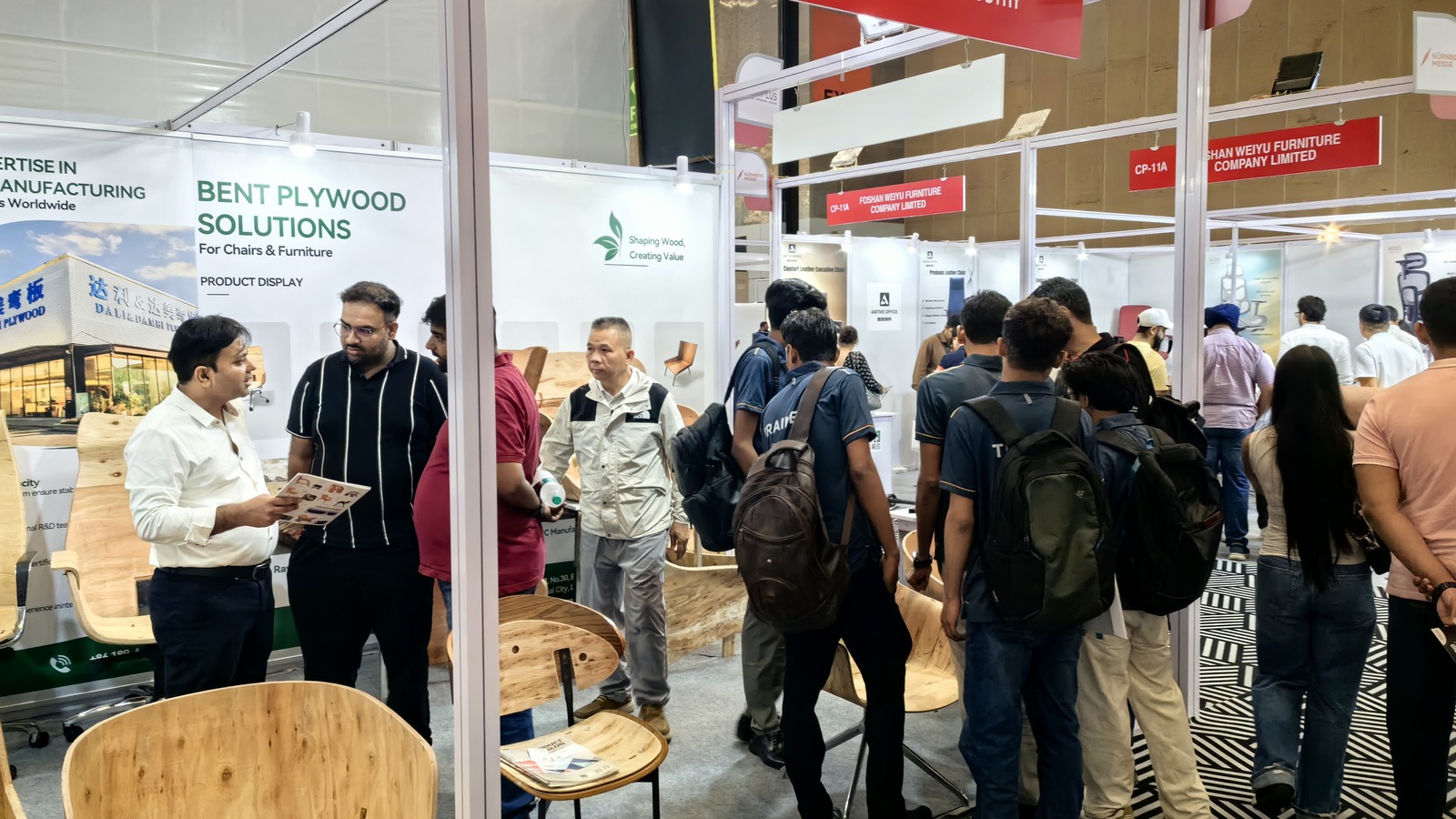 Busy exhibition aisle and buyer conversations beside DALI Wood Industry Booth CP-06 in New Delhi.